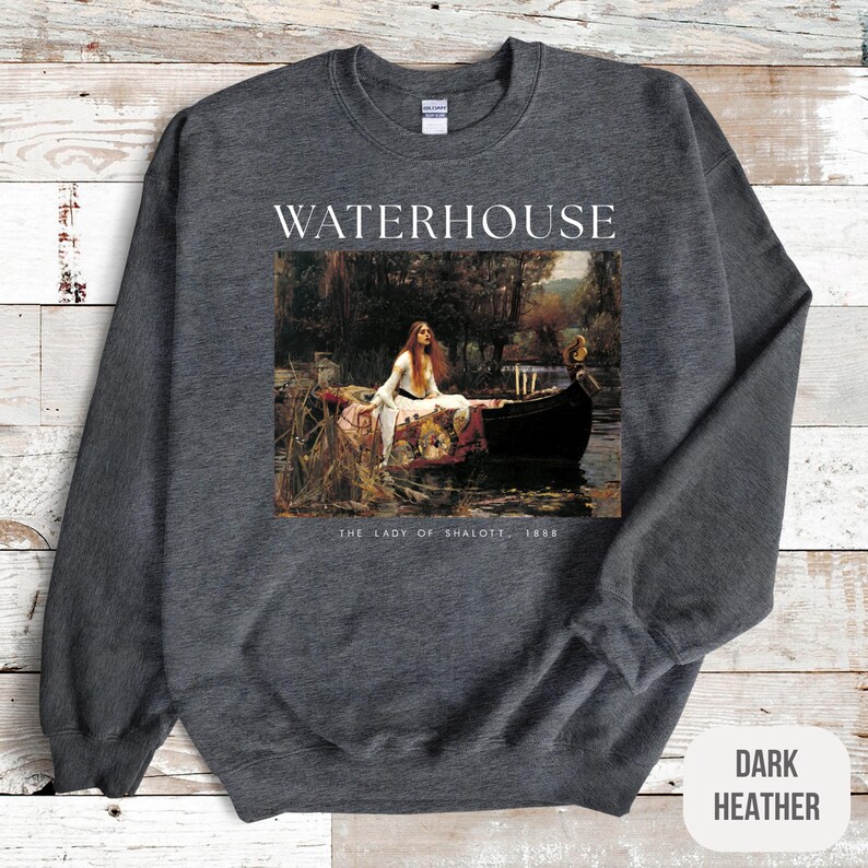 May include: Dark heather grey sweatshirt with a print of John William Waterhouse's painting "The Lady of Shalott" and the text "WATERHOUSE" above the image and "THE LADY OF SHALOTT - 1888" below the image.