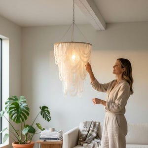 以下が含まれることがあります： 階層的なカスケードデザインの装飾シャンデリア。照明器具はチェーンで天井から吊り下げられています。シャンデリアは暖かく魅力的な輝きがあり、半透明の素材で作られています。