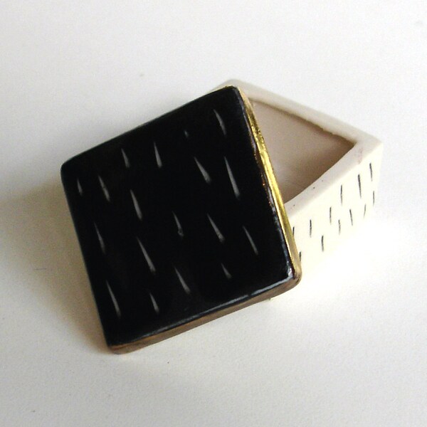 tiny black and white porcelain box with underglaze pencil and scrafitto decoration and 22k bright gold luster