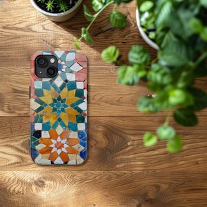 May include: A colorful phone case with a geometric pattern of green, blue, yellow, orange, and red tiles. The case has a cutout for the camera lens.