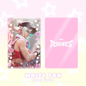 May include: A glossy card featuring a character illustration with a white and red color scheme. The card's front displays a character with white hair and a visor, while the back has the "Marvel Rivals" logo on a pink background. The text "WHITE FOX" and "glossy finish" are at the bottom.