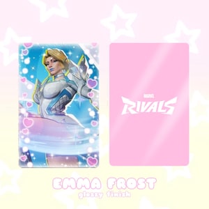 May include: A glossy trading card featuring Emma Frost from Marvel Rivals. The front displays a character illustration with a blue and white color scheme, surrounded by hearts. The back is pink with the Marvel Rivals logo.