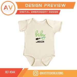 K&ouml;nnte beinhalten: Cremefarbener Baby-Body mit dem Wort "baby" in gr&uuml;ner Schrift, einem blauen Lichtschwert und dem Wort "JEDI" in Schwarz. Das Design ist eine digitale Stickerei-Vorschau. Der Text "DESIGN PREVIEW" und "DIGITAL EMBROIDERY DESIGN" sind ebenfalls vorhanden.