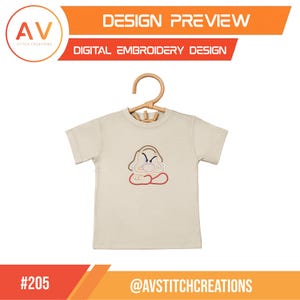 Puede incluir: Una camiseta beige de manga corta con un dise&ntilde;o bordado centrado de un personaje de dibujos animados gru&ntilde;&oacute;n con nariz grande, cejas fruncidas y brazos cruzados. El dise&ntilde;o incluye el texto DESIGN PREVIEW, DIGITAL EMBROIDERY DESIGN y #205.