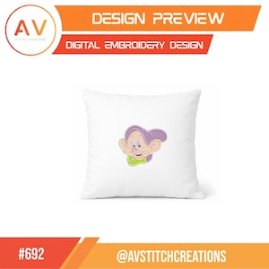 K&ouml;nnte beinhalten: Wei&szlig;es quadratisches Kissen mit einem farbenfrohen gestickten Design einer Zeichentrickfigur mit lila Ohren, einem rosa Gesicht und einem gr&uuml;nen Kragen. Das Kissen ist eine Designvorschau f&uuml;r digitale Stickerei. Der Text "DESIGN PREVIEW" und "DIGITAL EMBROIDERY DESIGN" sind sichtbar.