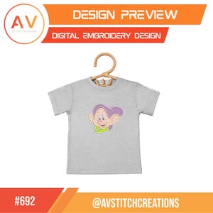 K&ouml;nnte beinhalten: Ein hellgraues T-Shirt mit einer Cartoonfigur mit lila Hut und gr&uuml;nem Kragen, das an einem Holzb&uuml;gel h&auml;ngt. Der Text oben lautet "DESIGN PREVIEW" und "DIGITAL EMBROIDERY DESIGN". Unten steht der Text "#692" und "@AVSTITCHCREATIONS".