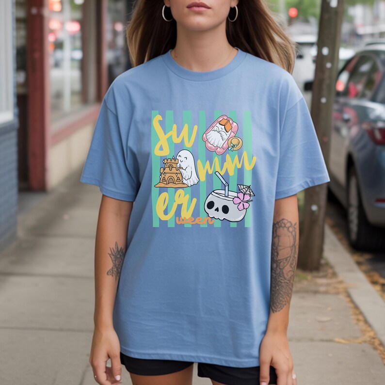 Cute Summerween ghost shirt design with striped background, ghost building sandcastle, ghost on float, skull coconut drink and tropical spooky summer aesthetic