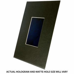 Puede incluir: Una cartulina negra con un hueco rectangular para una foto u otro objeto. La cartulina est&aacute; hecha de un papel grueso y texturizado.