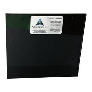 Puede incluir: Un cuadrado negro con una pegatina blanca en la esquina superior derecha. La pegatina tiene un logotipo y texto que dice "AuthentiBrand Inc. Authentication Branding Promotion RETAIL/WHOLESALE www.hologramplace.com stores.ebay.com/Holograman" y "INSTRUCCIONES DE ILUMINACI&Oacute;N Para obtener los mejores resultados, vea bajo un foco (MR-16 o bombilla LED &uacute;nica); o, en la luz solar directa. Los hologramas aparecer&aacute;n borrosos y poco claros si se ven bajo luz fluorescente u otra luz difusa."