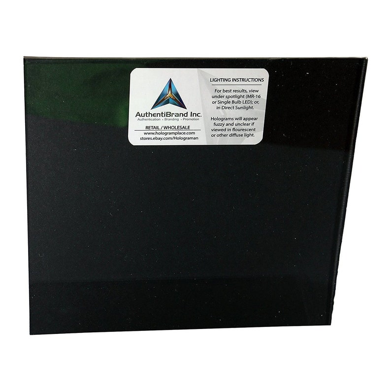 Puede incluir: Un cuadrado negro con una pegatina blanca en la esquina superior derecha. La pegatina tiene un logotipo y texto que dice "AuthentiBrand Inc. Authentication Branding Promotion RETAIL/WHOLESALE www.hologramplace.com stores.ebay.com/Holograman" y "INSTRUCCIONES DE ILUMINACI&Oacute;N Para obtener los mejores resultados, vea bajo un foco (MR-16 o bombilla LED &uacute;nica); o, en la luz solar directa. Los hologramas aparecer&aacute;n borrosos y poco claros si se ven bajo luz fluorescente u otra luz difusa."