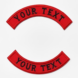 May include: Two red, arched patches with black embroidered text that reads "YOUR TEXT". The patches are a classic design, often used for customization on jackets or vests. The patches are set against a white background.