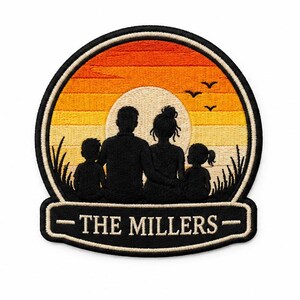 Puede incluir: Un parche bordado circular que muestra la silueta de una familia de cuatro personas sobre un fondo de atardecer con rayas horizontales naranjas y amarillas. El texto THE MILLERS está bordado en una banda rectangular blanca en la parte inferior.