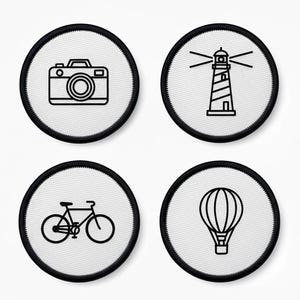 May include: Four circular patches with black borders and white centres. The patches feature line art illustrations of a camera, a lighthouse, a bicycle, and a hot air balloon. The designs are in black.