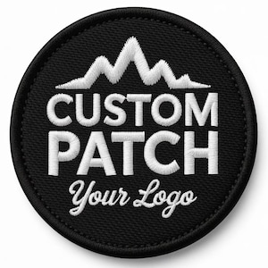 Puede incluir: Un parche redondo bordado en negro con texto blanco y un diseño de cordillera. El texto dice "CUSTOM PATCH" encima de "Your Logo". Adecuado para ropa o accesorios.