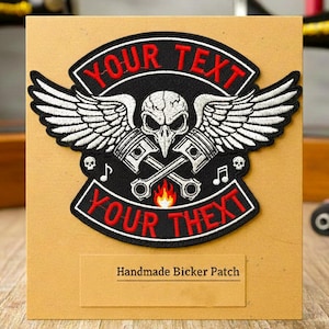May include: Black and white embroidered biker patch with a skull, pistons, and wings design. The patch has the text "YOUR TEXT" in red and includes the text "Handmade Bicker Patch". The patch is displayed on a brown card.