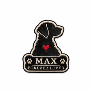 Op de afbeelding: Een geborduurde patch met het silhouet van een zwarte hond in profiel met een klein rood hartje op de borst. Onder de hond staat een botvormige banner met de tekst MAX geflankeerd door twee pootafdrukken en de tekst FOREVER LOVED.