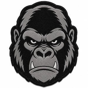 May include: An embroidered patch featuring the head of a gorilla in shades of black and gray. The design shows the gorilla with a stern facial expression, visible fangs, and detailed fur texture, outlined with a thick black border.