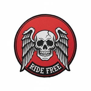 Könnte beinhalten: Gestickter Aufnäher mit einem weißen Totenkopf und detaillierten Flügeln, vor einem roten kreisförmigen Hintergrund. Der Schriftzug "RIDE FREE" ist unter dem Totenkopf angeordnet. Der Aufnäher hat einen schwarzen Rand.