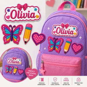 Può includere: Uno zaino viola con toppe ricamate raffiguranti un'etichetta con il nome Olivia e un fiocco rosa, una farfalla colorata, una matita gialla e un cuore rosa a pois bianchi. Le toppe sono mostrate anche separatamente su uno sfondo bianco.