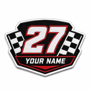 Peut inclure: Un écusson brodé en forme de bouclier affichant le numéro 27 en blanc avec un contour rouge, flanqué de deux drapeaux de course à damier noir et blanc. Sous le numéro, une bannière rouge contient le texte blanc YOUR NAME sur fond noir.