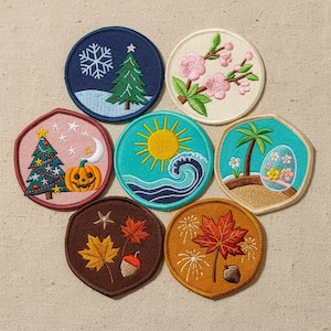 Puede incluir: Siete parches bordados circulares con diseños estacionales: un árbol de invierno, flores de cerezo rosas, un árbol de Navidad decorado con una calabaza, un sol amarillo brillante sobre olas, una playa tropical, hojas de otoño y una hoja de arce.