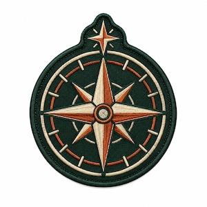 May include: A circular embroidered patch featuring a dark green background with a central compass rose design. The compass rose is composed of alternating cream and burnt orange segments, surrounded by a circular border with tick marks.