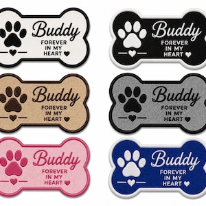 Könnte beinhalten: Sechs knochenförmige Stickaufnäher in Weiß, Schwarz, Beige, Grau, Pink und Blau. Jeder Aufnäher zeigt einen Pfotenabdruck, den Namen Buddy und den Text FOREVER IN MY HEART mit kleinen Herzsymbolen. Die Aufnäher haben eine deutliche Umrandung.