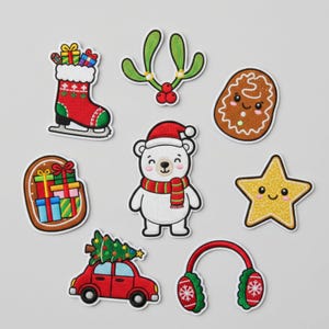 Op de afbeelding: Een verzameling kerst-thema geborduurde patches. Ontwerpen omvatten een rode kous op schaatsen, een peperkoekman, een ijsbeer met een kerstmuts en sjaal, een rode auto met een kerstboom en een gouden ster.