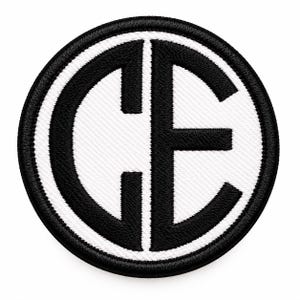 May include: A circular embroidered patch featuring a black border and a white background. The center displays the bold black capital letters C and E, which are joined together to form a single, unified monogram design.