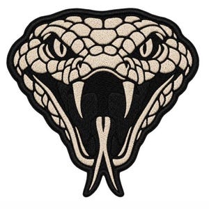 Pode incluir: Um emblema bordado apresentando a cabeça de uma cobra em vista frontal. O design utiliza um esquema de cores de alto contraste com escamas e presas na cor creme sobre um fundo preto profundo, exibindo a boca aberta e a língua.