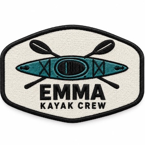 May include: An embroidered patch with a cream-coloured background and a black border. It features a teal kayak with black accents and two crossed black paddles. Below the kayak, the text EMMA KAYAK CREW is embroidered in bold black capital letters.