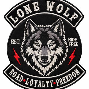 Peut inclure: Un écusson brodé circulaire représentant une tête de loup grise et blanche au centre. Le texte LONE WOLF est arqué en haut, avec EST. RIDE FREE sur les côtés, et ROAD LOYALTY FREEDOM en bas. Deux éclairs rouges entourent le loup.