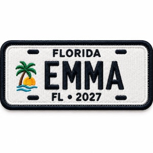 Könnte beinhalten: Ein rechteckiger bestickter Aufnäher im Design eines Florida-Nummernschilds mit weißem Hintergrund und schwarzem Rand. Er zeigt den Text FLORIDA, EMMA und FL 2027 in Schwarz sowie eine kleine Stickerei einer Palme und einer orangefarbenen Sonne.