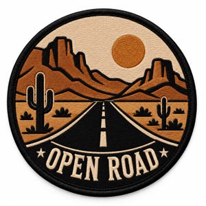 Puede incluir: Un parche bordado circular que muestra un paisaje desértico con una carretera negra que conduce a montañas bajo un sol naranja redondo. Dos cactus se encuentran a ambos lados de la carretera. El texto OPEN ROAD está bordado en blanco con dos estrellas.
