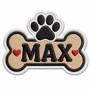 Könnte beinhalten: Ein gestickter Aufnäher in Form eines beigen Hundeknochens mit schwarzem Rand und weißer Umrandung. Der Name MAX ist in schwarzen Buchstaben in der Mitte eingestickt, flankiert von zwei kleinen roten Herzen. Eine schwarze Pfote liegt über dem Knochen.