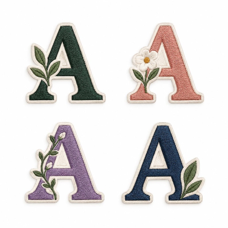 Op de afbeelding: Vier geborduurde patches in de vorm van de letter A met witte randen. Linksboven een donkergroene letter met bladeren. Rechtsboven een oudroze letter met een witte bloem. Linksonder een lavendelkleurige letter met een rank. Rechtsonder een marineblauwe letter met bladeren.