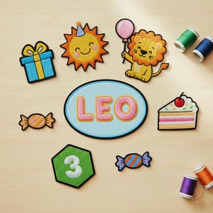 May include: A collection of colorful embroidered patches, including a gift box, a smiling sun, a lion holding a balloon, a cake slice, and candies. A patch with the name "LEO" and a number "3" are also present. Sewing thread spools are visible.