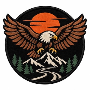 May include: A circular embroidered patch featuring a bald eagle with brown wings spread wide against a black background. Below the eagle are white snow-capped mountains, green pine trees, and a winding road under a large orange sun.
