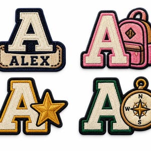 Peut inclure: Quatre écussons brodés représentant la lettre A. Un écusson inclut le nom ALEX, un autre un sac à dos rose, un troisième une étoile dorée et le dernier une boussole. Chaque écusson possède une bordure distincte en bleu marine, rose, jaune ou vert.