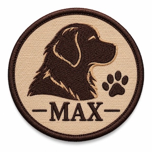 Op de afbeelding: Een ronde geborduurde patch met een beige achtergrond en een donkerbruine rand. Het ontwerp toont het donkerbruine silhouet van een hondenkop in profiel, een kleine donkerbruine pootafdruk en de tekst MAX gecentreerd tussen twee lijnen.