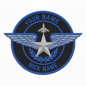 Puede incluir: Parche bordado con fondo negro y borde azul. El diseño presenta una estrella plateada, alas y un avión a reacción. Los textos "YOUR NAME" y "NICK NAME" están bordados en azul alrededor del círculo.