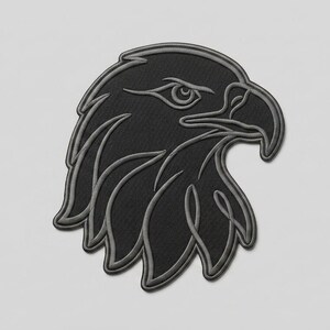 Könnte beinhalten: Ein schwarzer Stickaufnäher mit dem Profil eines Adlerkopfes. Das Design verwendet dunklen Faden, um die Form des Vogels zu erzeugen, mit einem scharfen Schnabel und detaillierten Federn, die in einem helleren Grauton auf schwarzem Grund umrandet sind.