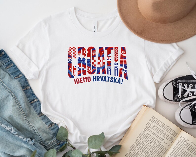 a white t-shirt with a graphic design, a hat, a pair of jeans, a book, and some sneakers.