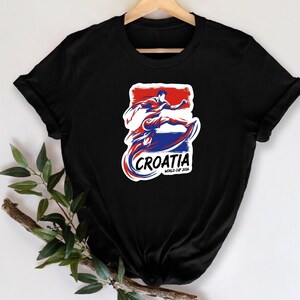 A black t-shirt with a graphic design featuring a stylized figure in red, white, and blue colors, along with the text "Croatia" and "World Cup 2006".