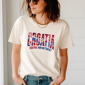A woman wearing a white t-shirt with a graphic design and text printed on it.