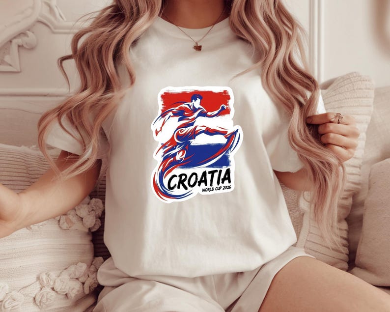 A woman wearing a white t-shirt with a graphic of a person surfing and the text "Crotia World Cup 2018" printed on it.
