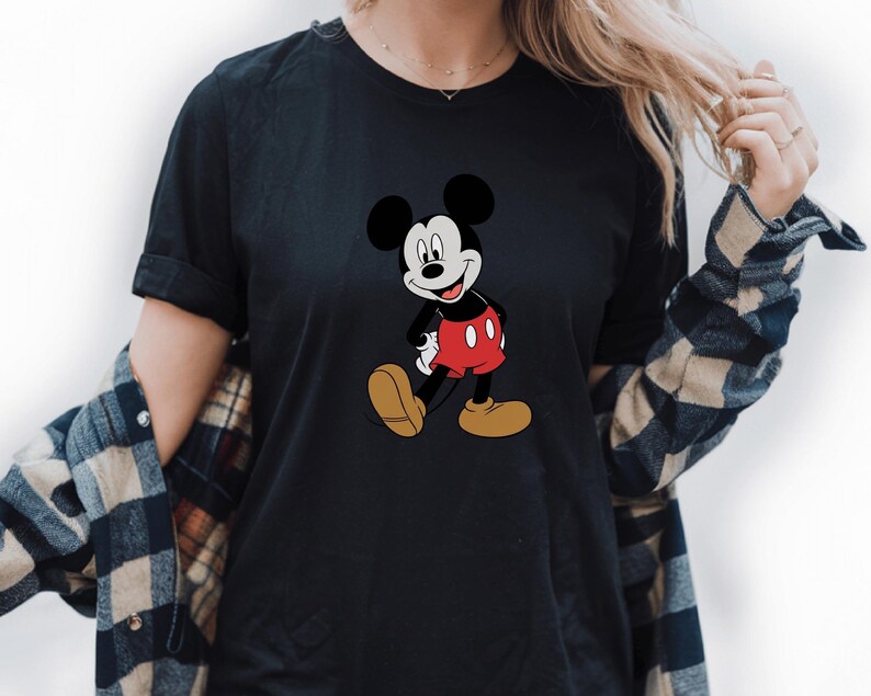 A woman wearing a black t-shirt with a Mickey Mouse graphic printed on it.