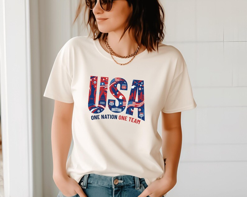 A woman wearing a white t-shirt with the text "USA" and "ONE NATION ONE TEAM" printed on it.