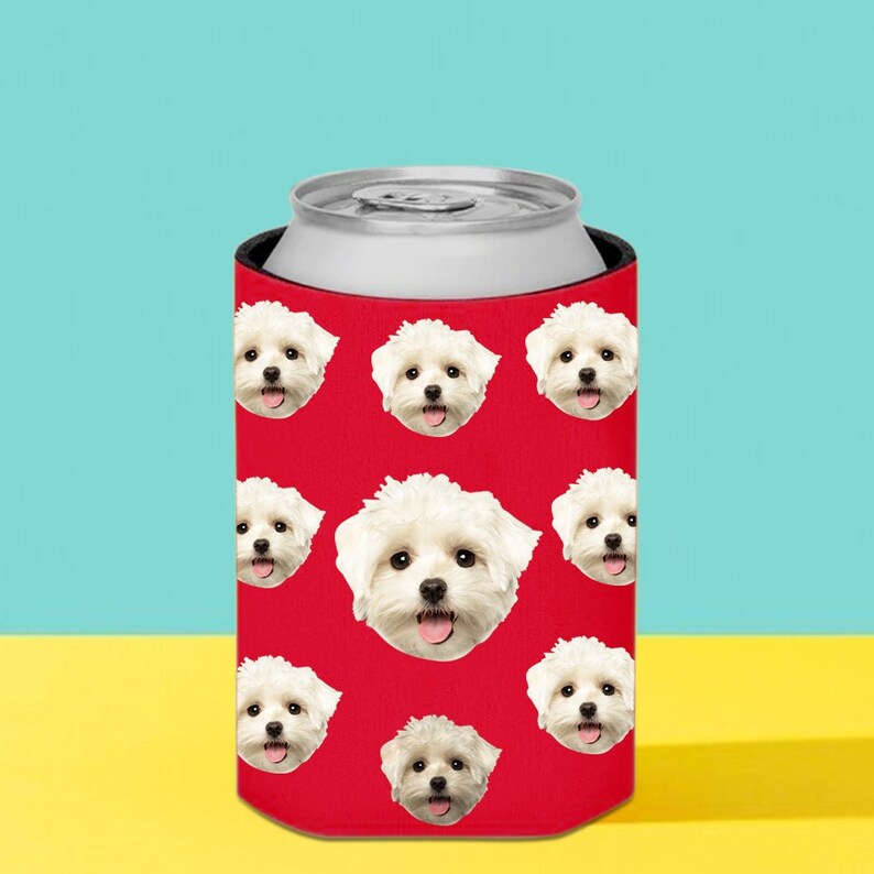 Puede incluir: Un enfriador de latas rojo con un patr&oacute;n repetido de caras de perros blancos. El enfriador est&aacute; dise&ntilde;ado para una lata de tama&ntilde;o est&aacute;ndar. El fondo es un degradado de amarillo y azul.