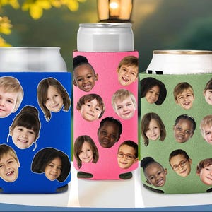May include: Three colorful can coolers. One is blue, one is pink, and one is green. Each cooler is decorated with smiling children's faces. The coolers are designed to keep beverages cold.
